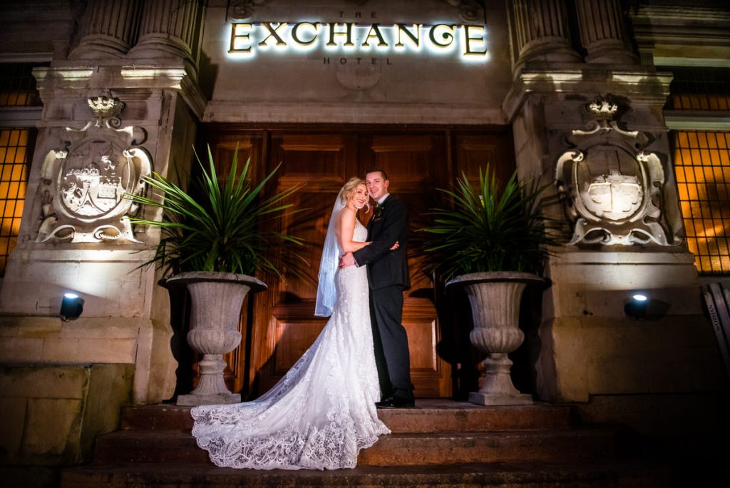 bride and her groom standing at the Exchange Hotle entrance on their wedding day