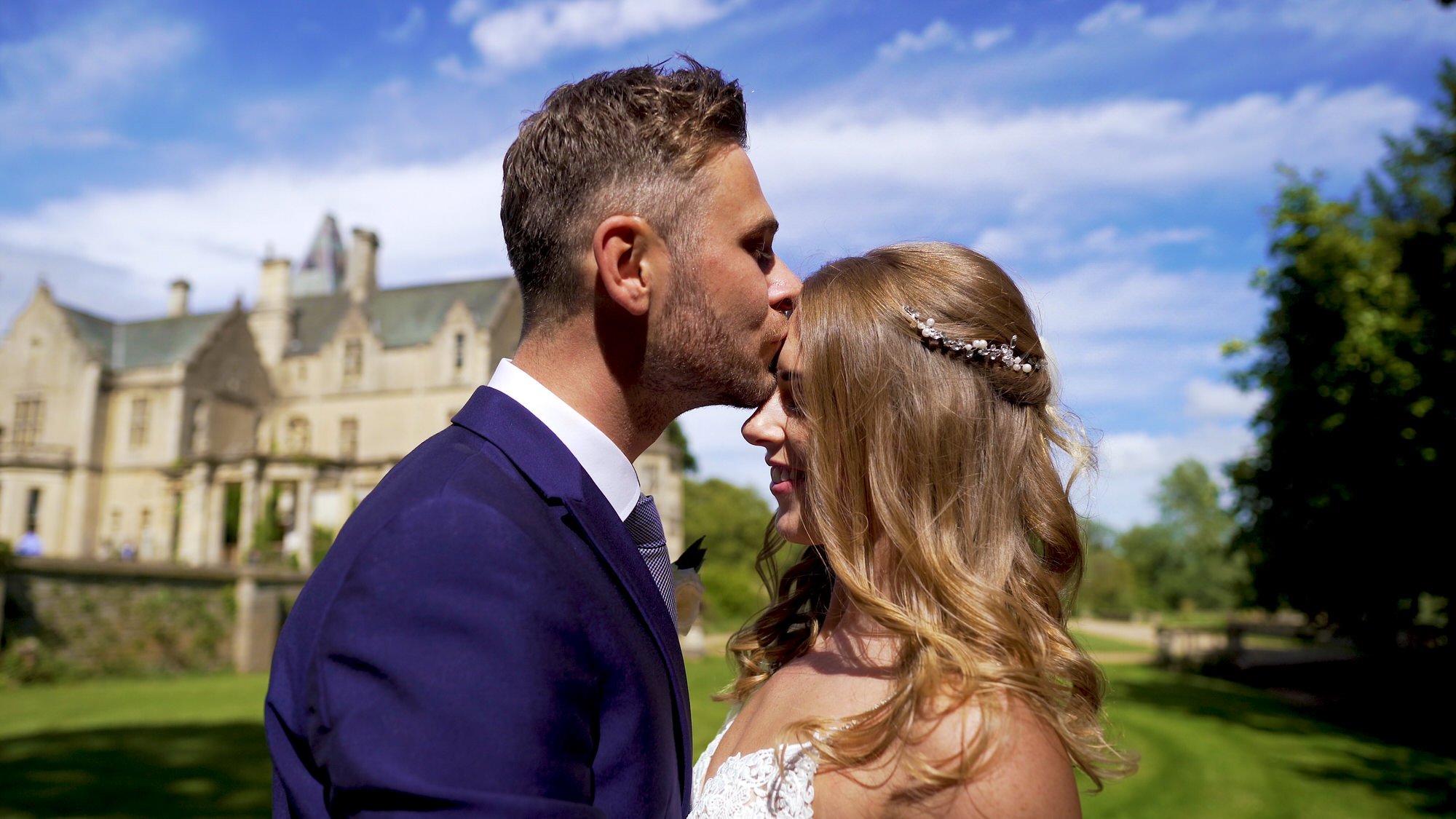 Bride and Groom kiss on their wedding day with the wonderful Orchardleigh Estate in the back ground